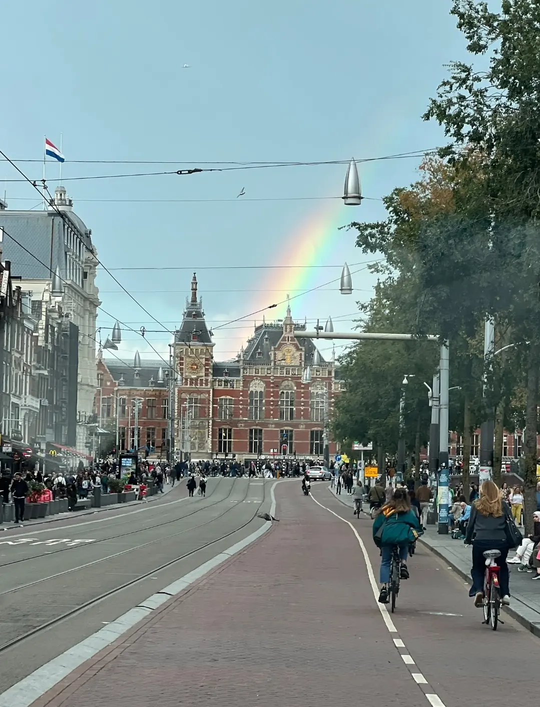 Amsterdam Centraal Station met een regenboog boven de stad